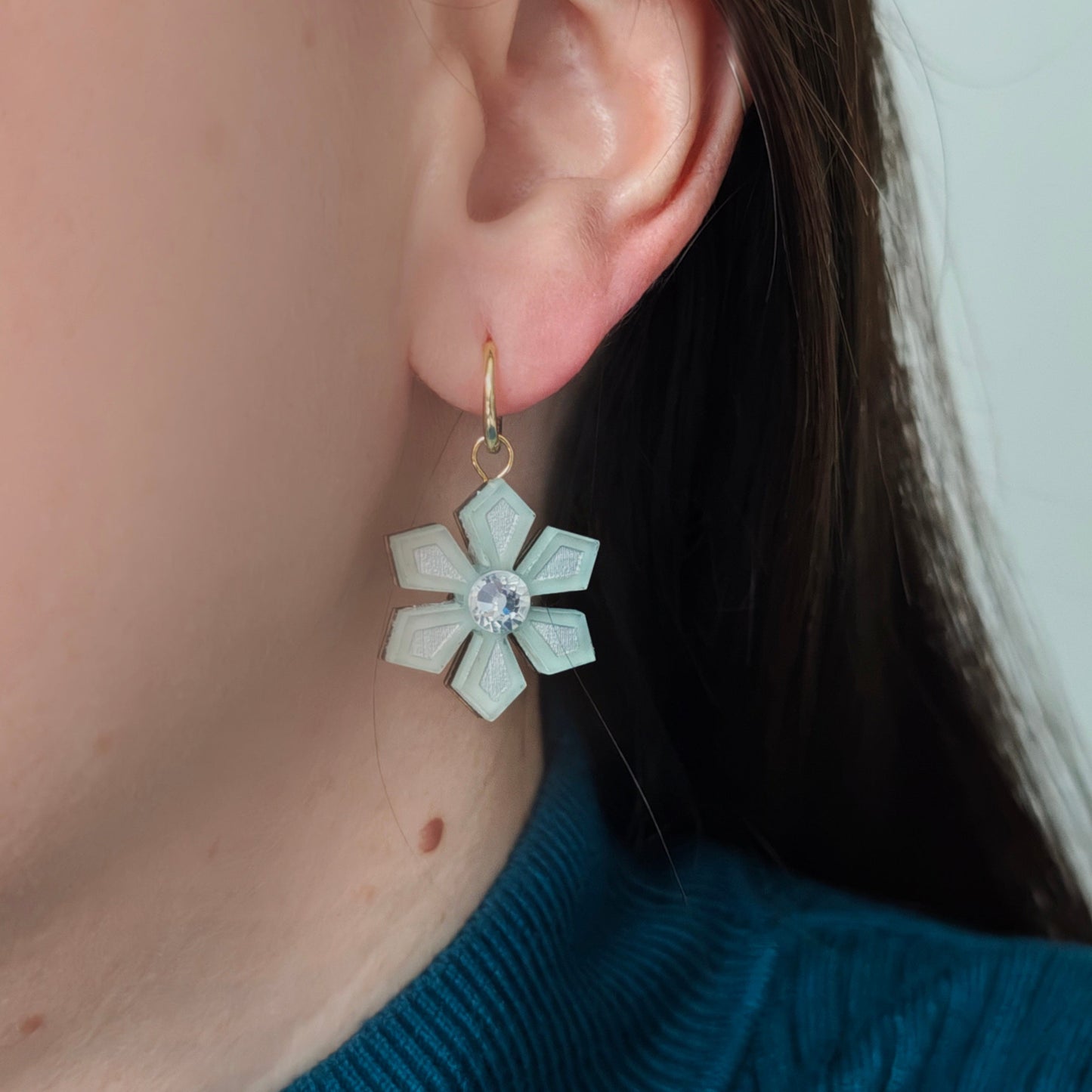 Close-up of a person wearing a snowflake earring