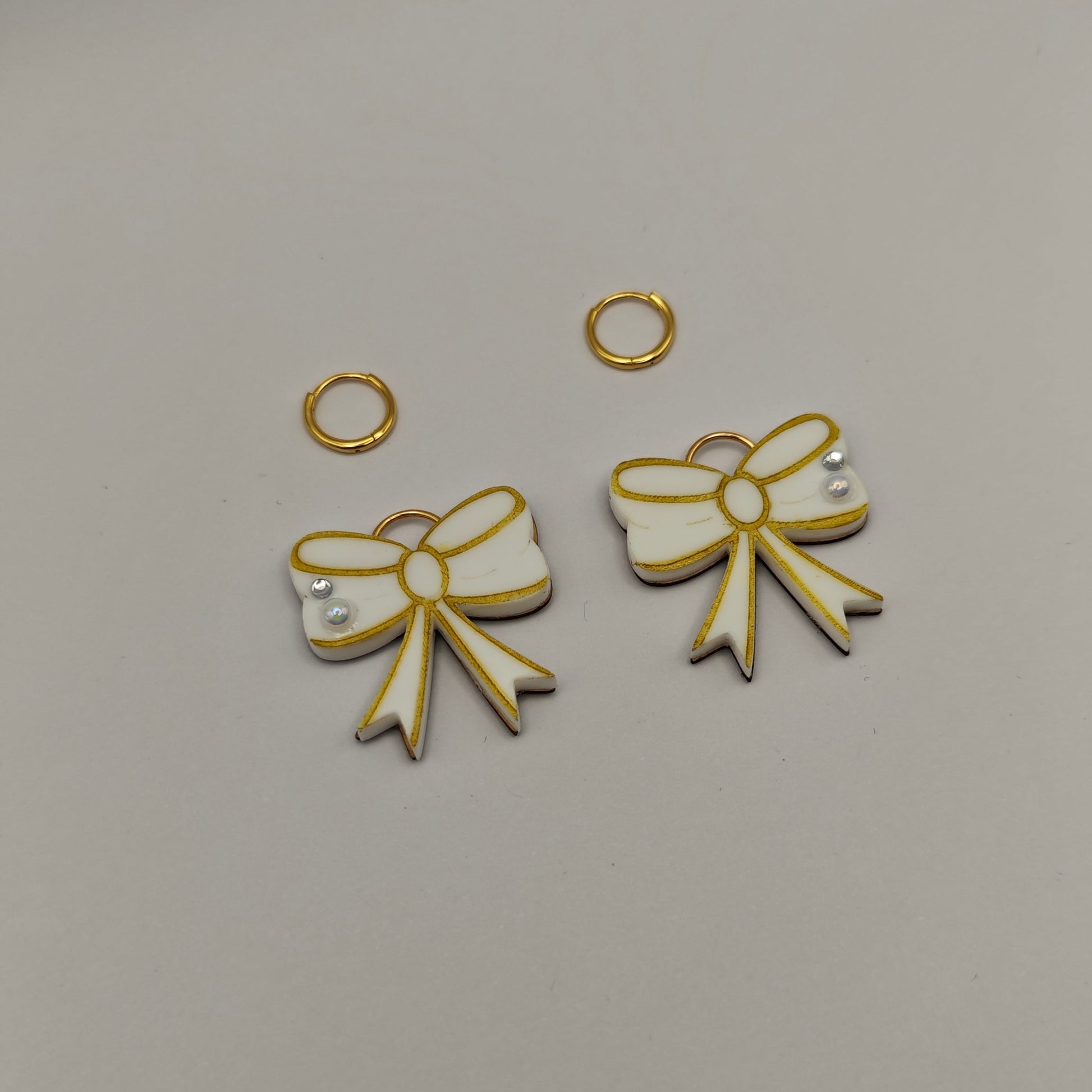 gold and white bow-shaped charms