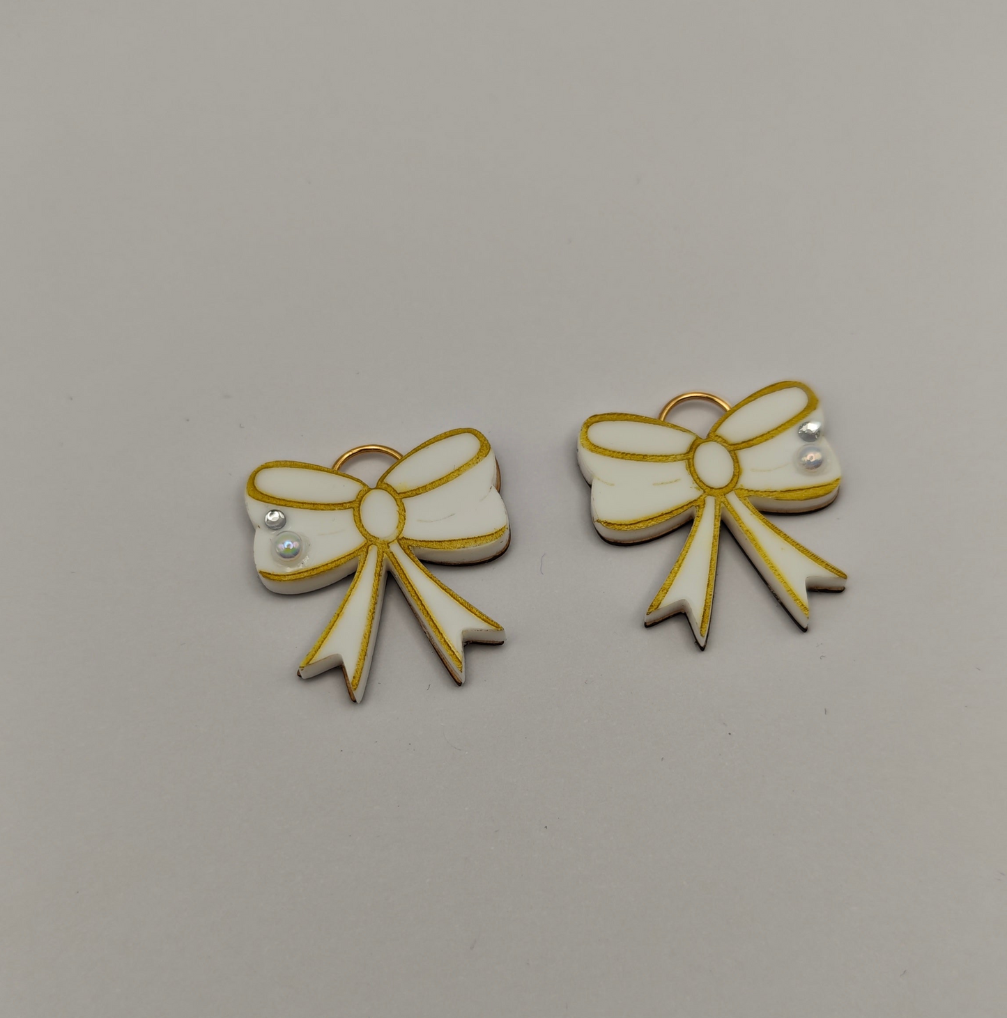 gold and white bow-shaped charms